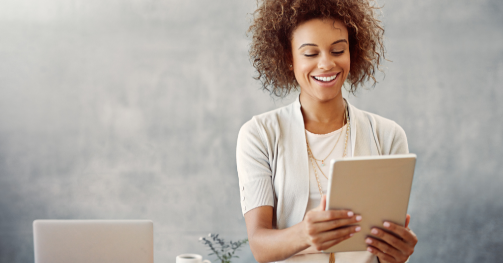 woman looking at her ipad and smiling